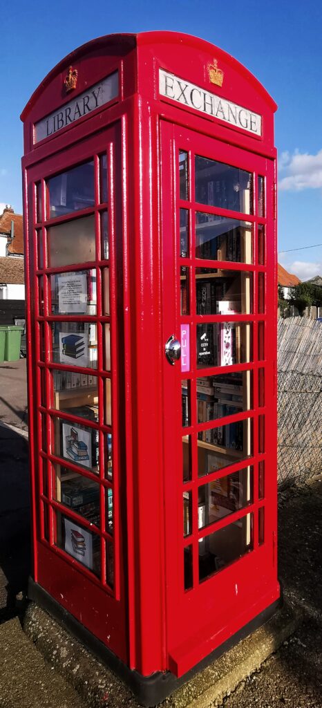 a Local free library book swapping service inside an old red, telephone box once found everywhere in the UK