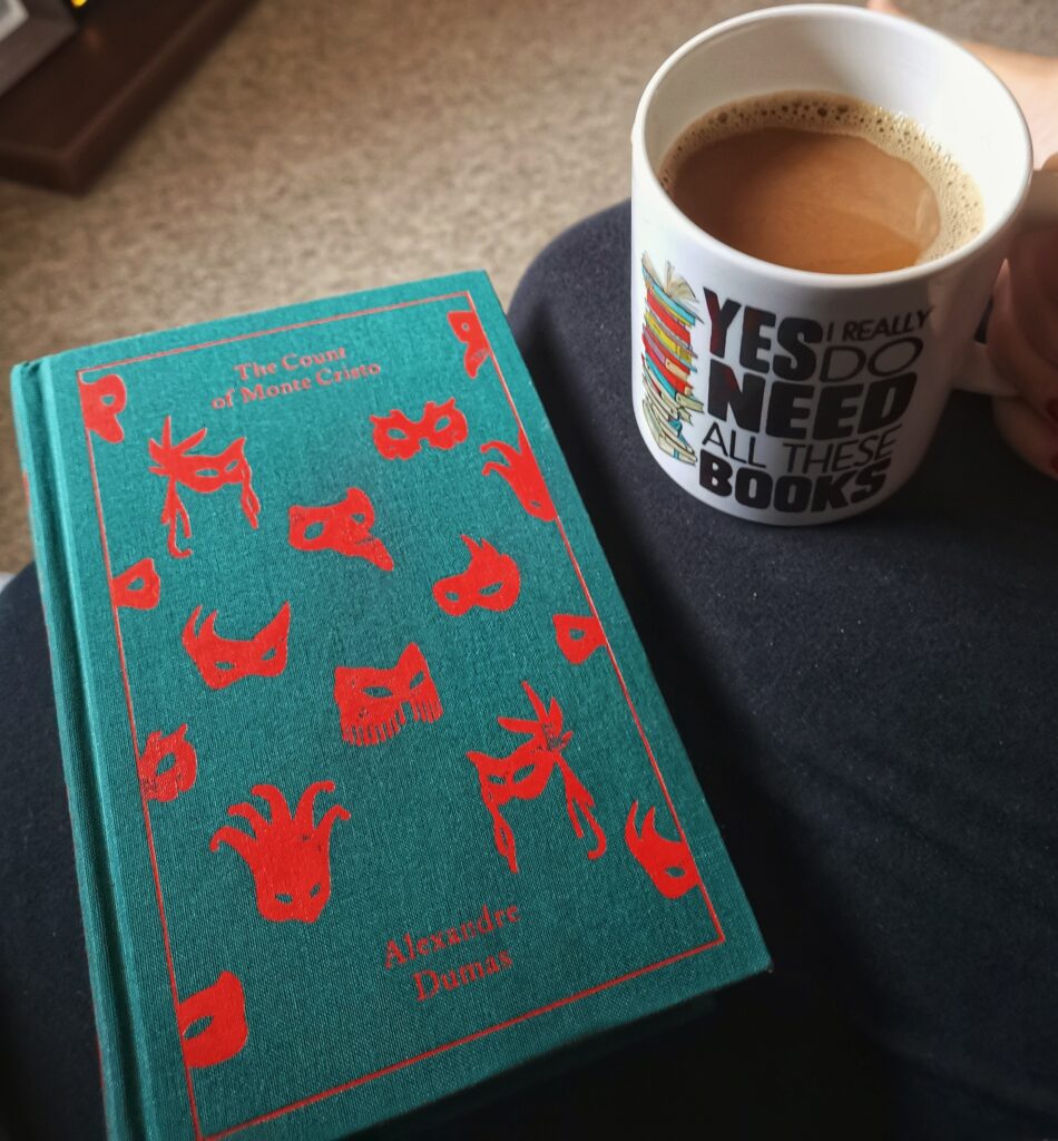 the cloth bound classic The Count of Monte Cristo and a mug of coffee