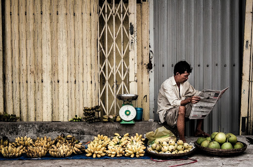 The streets of Vietnam where people sell food and spend the day reading newspapers while waiting for customers.