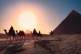 A camel train walking away from the Pyramids in Egypt