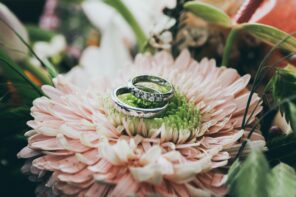 Wedding rings set on a pink flower.